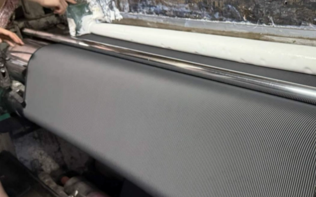 Woven fabric running through textile inspection equipment